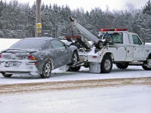 tow truck and car in snow.